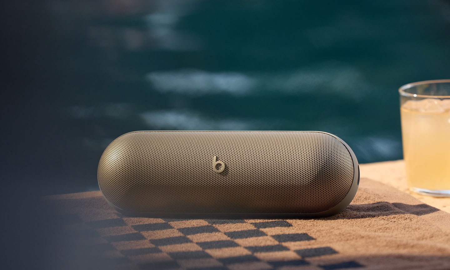 سماعة Beats Pill 2024 موضوعة في الخارج قرب الماء لتوضيح الاستخدام المحمول